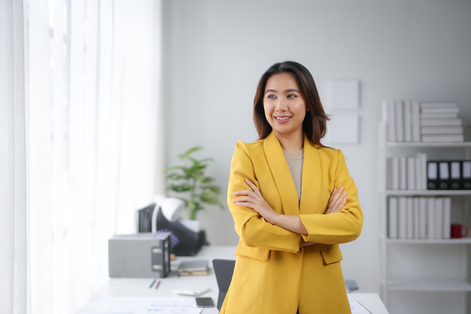 Confident businesswoman in a yellow blazer with arms crossed